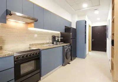 a kitchen with blue cabinets and a washer and dryer at Lux 1BR Apt with BurjKhalifa Views in DowntownDubai in Dubai