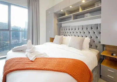 a bedroom with a large bed with a large window at Lux 1BR Apt with BurjKhalifa Views in DowntownDubai in Dubai