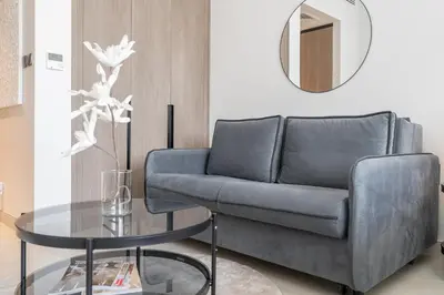 a living room with a couch and a table at Bright & Modern Studio - Legacy By Sunrise - Arjan in Dubai