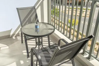 a glass table and a chair on a balcony at Bright & Modern Studio - Legacy By Sunrise - Arjan in Dubai