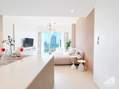 a white kitchen with a bed and a living room at Grande Luxury 1B With Balcony & City Views in Dubai