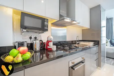 a kitchen with a bowl of fruit on a counter at Vogue Business Bay Damac Maison Prive near Burj Khalifa and Dubai Mall, Studio Apartment with Balcony, Canal and City View, Access to all Amenities in Dubai