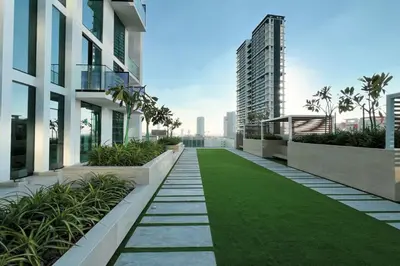an apartment balcony with green grass and buildings at Binghatti House in JVC - New Apartment in Dubai