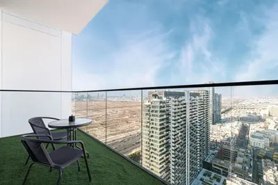 a balcony with a table and chairs in a building at Binghatti House in JVC - New Apartment in Dubai