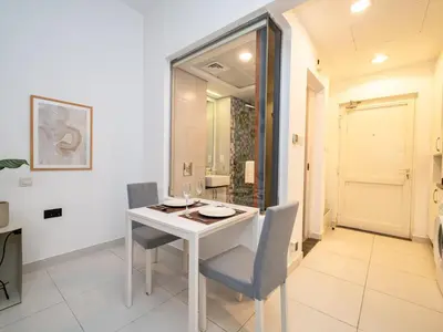 a dining room with a white table and chairs at Chic Waterfront Studio in Palm Views West in Dubai