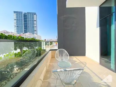 a balcony with two chairs and a table at Deluxe 2-Bedroom Apartment - JVC Binghatti Emerald in Dubai
