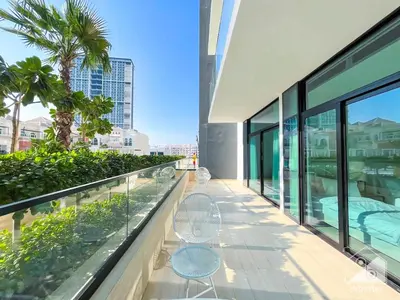 a balcony of a building with two chairs at Deluxe 2-Bedroom Apartment - JVC Binghatti Emerald in Dubai