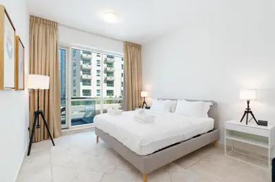 a bedroom with a white bed and a large window at Stylish 1-Bedroom with Breathtaking Views at Dubai Marina in Dubai