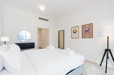 a white bedroom with a large bed and a tripod at Stylish 1-Bedroom with Breathtaking Views at Dubai Marina in Dubai
