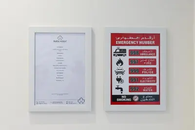 a picture of a emergency number sign on a wall at Stylish 1-Bedroom with Breathtaking Views at Dubai Marina in Dubai