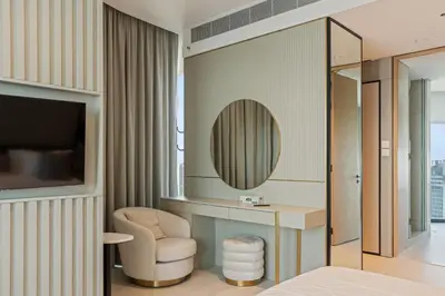 a bedroom with a desk and a chair and a mirror at Werova - Sea View 3BR with Hotel Facilities Access in Dubai