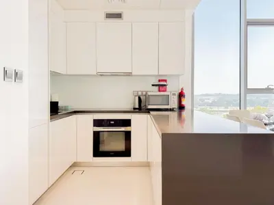 a kitchen with white cabinets and a black counter top at Azure - 1-Bed Luxury by Crystal Lagoon, Downtown in Dubai