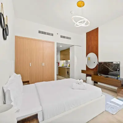 a living room with a white bed and a white couch at Azizi Riviera 35 - Studio with full Kitchenet - Ideal for monthly in Dubai