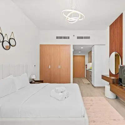 a bedroom with a large white bed and a mirror at Azizi Riviera 35 - Studio with full Kitchenet - Ideal for monthly in Dubai