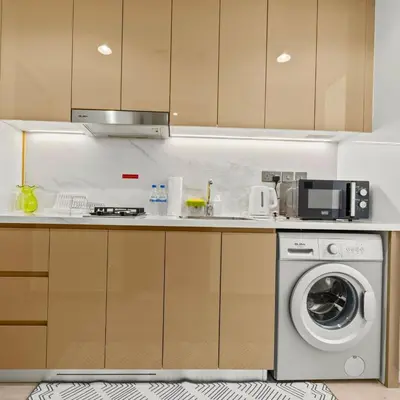 a kitchen with a washing machine and a microwave at Azizi Riviera 35 - Studio with full Kitchenet - Ideal for monthly in Dubai
