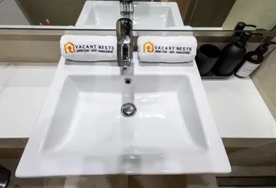 two sinks in a bathroom with two towels on it at 10 Mins from Downtown Pool Gym Large Terrace in Dubai