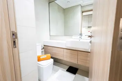 a bathroom with a sink and a toilet and a mirror at 10 Mins from Downtown Pool Gym Large Terrace in Dubai