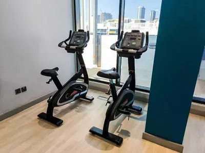 two exercise bikes in a room with a window at 10 Mins from Downtown Pool Gym Large Terrace in Dubai
