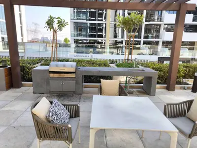 a patio with tables and chairs in a building at 10 Mins from Downtown Pool Gym Large Terrace in Dubai