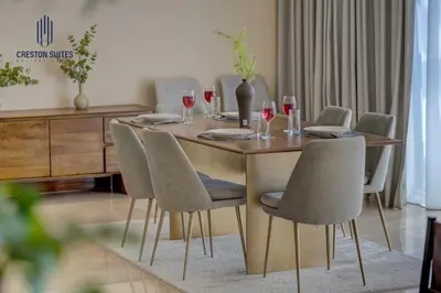 a dining room table with chairs and wine glasses at Creston Suites The Dubai Mall Residences in Dubai