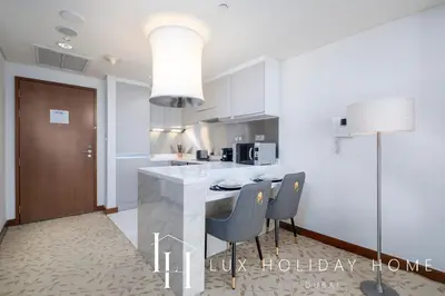 a kitchen with a counter with chairs and a table at LUX The EMAAR Fashion Avenue Studio 2 in Dubai