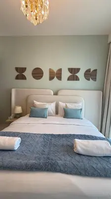 a bedroom with a large bed with a chandelier at Seaside Elegance 1BR at Emaar Beachfront in Dubai