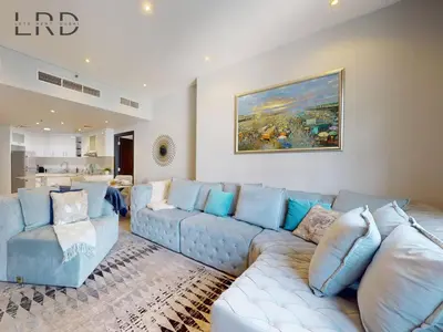 a large living room with a blue couch and chairs at Stylish 2BR Apartment Steps from Metro and Marina Mall in Dubai