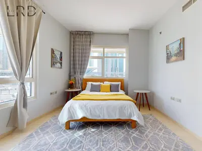 a bedroom with a bed and a window at Stylish 2BR Apartment Steps from Metro and Marina Mall in Dubai