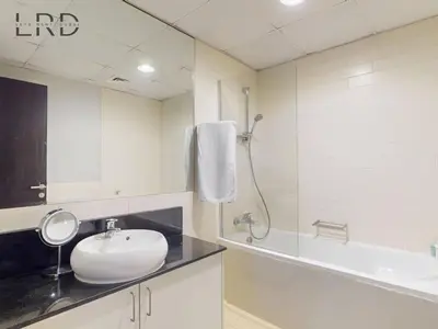 a bathroom with a sink and a shower and a tub at Stylish 2BR Apartment Steps from Metro and Marina Mall in Dubai