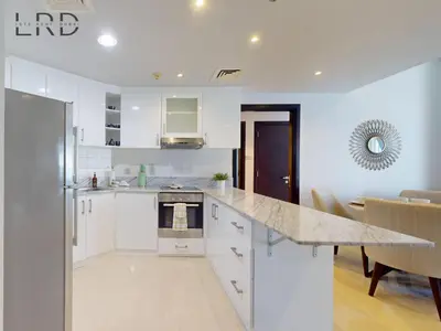 a kitchen with white cabinets and a counter top at Stylish 2BR Apartment Steps from Metro and Marina Mall in Dubai
