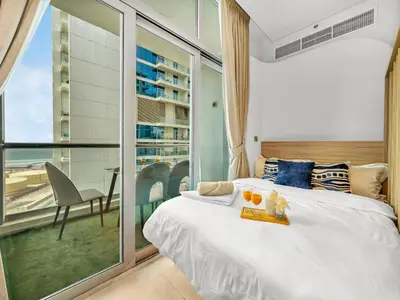 a bedroom with a large bed and a balcony at Luxurious 2BR Stay Marina View in Dubai