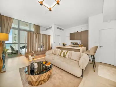 a living room with a couch and a kitchen at Luxurious 2BR Stay Marina View in Dubai