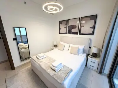 a bedroom with a white bed and a mirror at Great Location Near City Modern Sleeps 4 Guests in Dubai