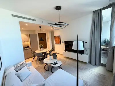 a living room with a white couch and a table at Great Location Near City Modern Sleeps 4 Guests in Dubai