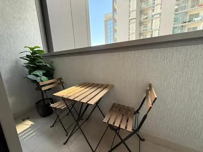 a wooden table and two chairs on a balcony at Great Location Near City Modern Sleeps 4 Guests in Dubai
