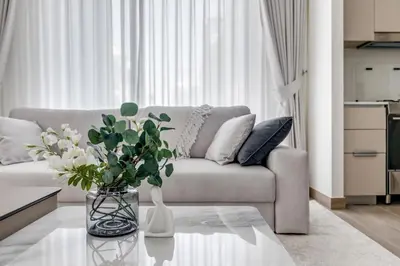 a living room with a couch and a table with flowers at Knokey Dubai Creek Beach with Lagoon Pool access in Dubai