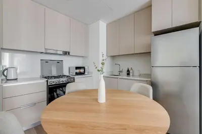 a kitchen with a wooden table with a vase on it at Knokey Dubai Creek Beach with Lagoon Pool access in Dubai