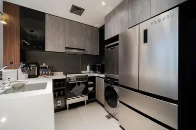 a kitchen with a stainless steel refrigerator and a dishwasher at SettlerHomes - Chic JLT 29 Floor Near Panoramic Lake in Dubai
