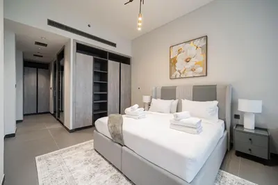 a bedroom with a large white bed with towels on it at SettlerHomes - Chic JLT 29 Floor Near Panoramic Lake in Dubai