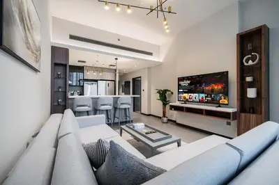 a living room with a couch and a tv at SettlerHomes - Chic JLT 29 Floor Near Panoramic Lake in Dubai
