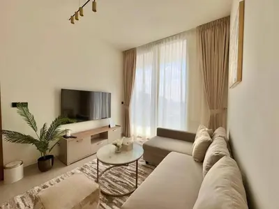 a living room with a couch and a tv at Modern 1br In Jvc Balcony, Pool & Parking in Dubai