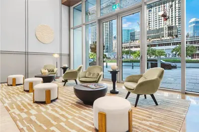 a lobby with chairs and tables and large windows at FIRST CLASS 2BR Burj Khalifa & Fountain view in Dubai
