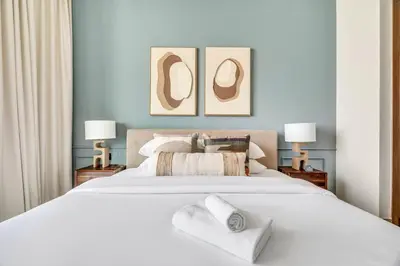 a bedroom with a large white bed with two lamps at GuestReady - Sky-High Luxury with a Private Pool in Dubai
