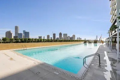 a large swimming pool with a city skyline in the background at GuestReady - Sky-High Luxury with a Private Pool in Dubai