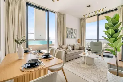 a living room with a table and a couch at GuestReady - Sky-High Luxury with a Private Pool in Dubai