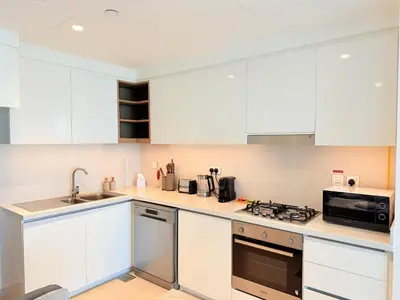 a kitchen with white cabinets and a stove top oven at 2 bedroom apartment infront of Dubai mall by Aventine homes in Dubai