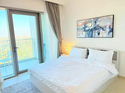 a bedroom with a white bed and a large window at 2 bedroom apartment infront of Dubai mall by Aventine homes in Dubai