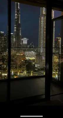 a view of a city at night from a window at Burj Royale Lux 2-bedroom apartment with the best Burj Khalifa view in Dubai