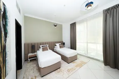a bedroom with two beds and a window at 2 Bed in Atlantic Tower 2 by PK Holidays in Dubai