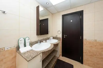 a bathroom with two sinks and a black door at 2 Bed in Atlantic Tower 2 by PK Holidays in Dubai